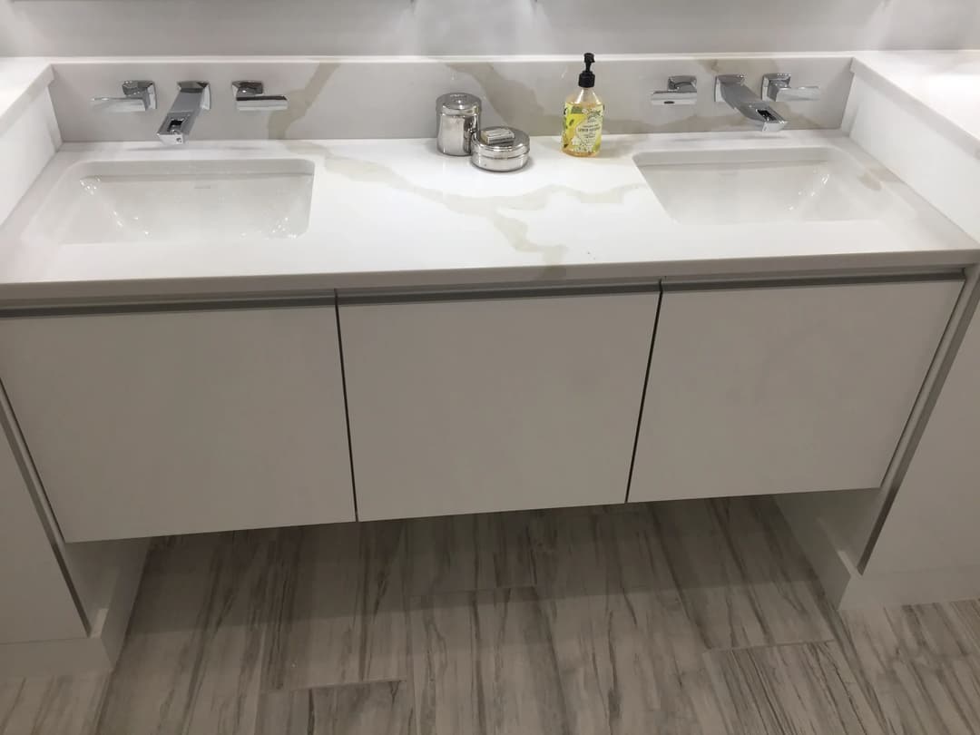 Modern bathroom vanity with dual sinks, silver faucets, and soap dispenser on a sleek countertop.