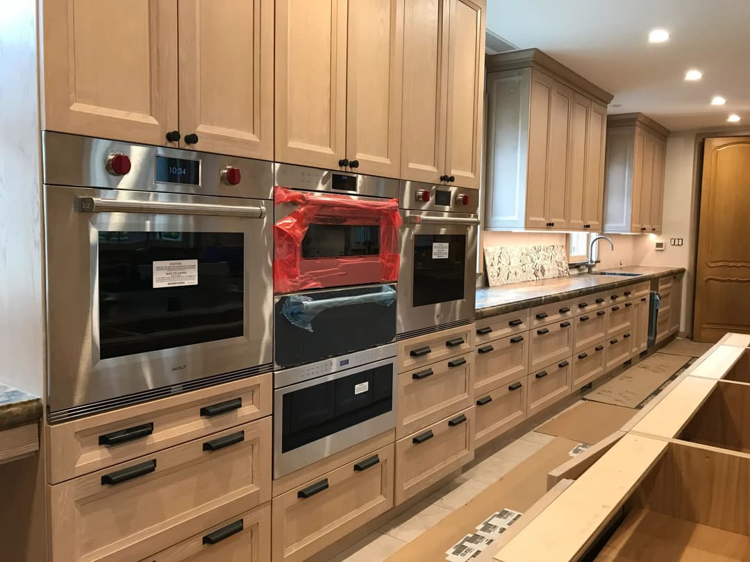 Modern kitchen with wooden cabinets, stainless steel appliances, and a red microwave.